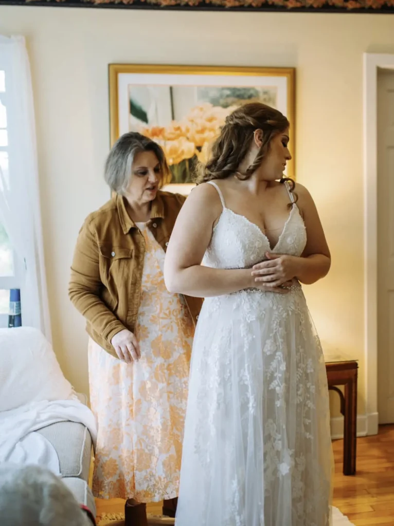 A mother adjusts the dress of her daughter before her wedding inside the bridal suite at Old Coon Creek Wedding Venue in Beloit, Wisconsin
