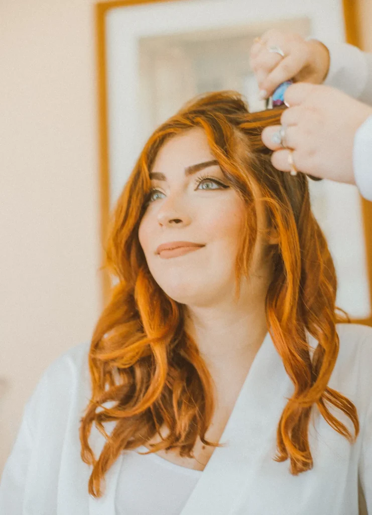 A bride gets her hair and makeup done at Old Coon Creek Wedding Venue in Beloit, Wisconsin